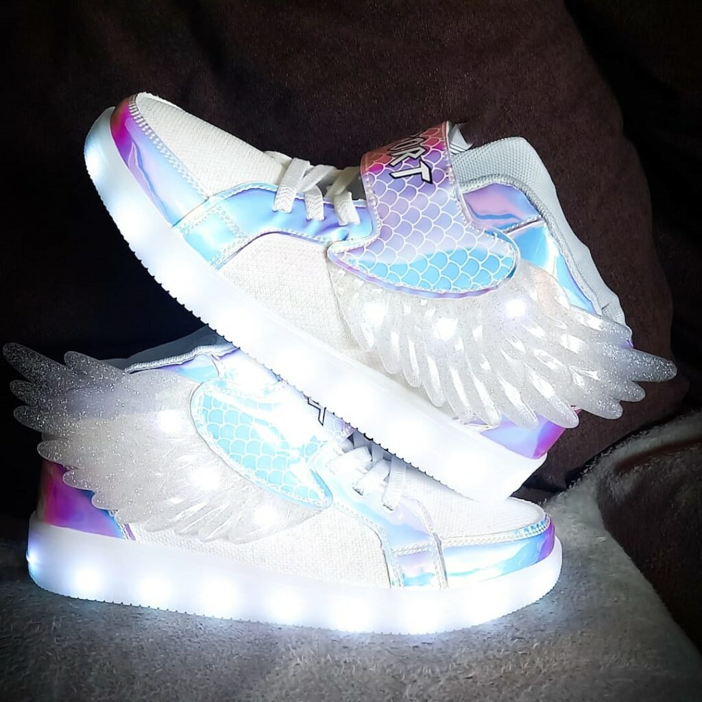 White sneakers with shiny elements and glittery wings, the sole is lit up by LEDs The wings are lit up a little too. 